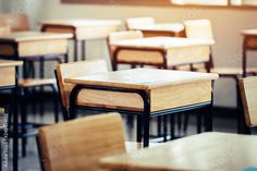 an empty classroom with wooden desks and chairs