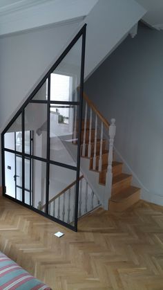 an empty living room with a staircase and glass door to the second floor in front of it