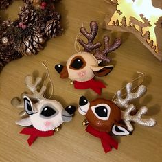 three reindeer ornaments sitting on top of a wooden table