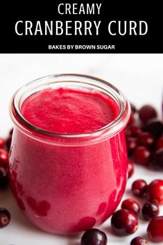 cranberry curd in a glass jar surrounded by berries