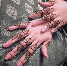 two hands with henna tattoos on them