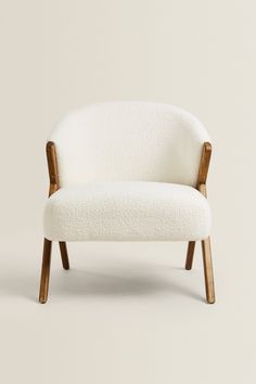 a white chair with wooden legs and arms