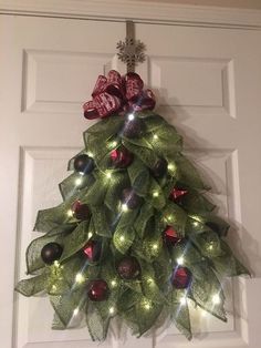 a christmas tree made out of mesh with candy candies hanging on the front door