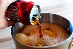 a person is pouring soda into a pot filled with ice cream and orange peels