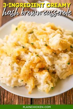 a white plate topped with mashed potatoes on top of a wooden table next to a fork