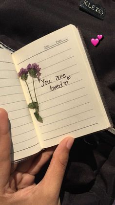 someone is holding an open book with writing on it that says, you are loved