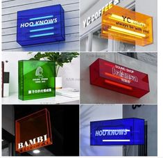 four different types of illuminated signs hanging from the side of a building in various colors