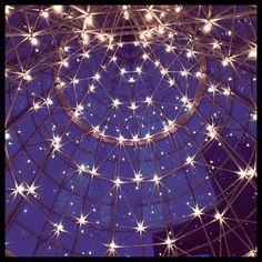 the inside of a glass dome with stars on it's ceiling and lights all around