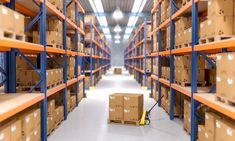 a large warehouse filled with lots of boxes and pallet racks on each side of the aisle