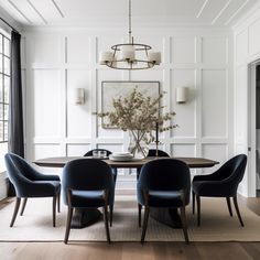 a dining room table with blue chairs and a chandelier hanging from the ceiling