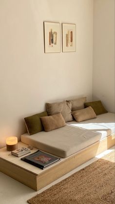 a bed sitting on top of a wooden platform next to a wall with pictures above it