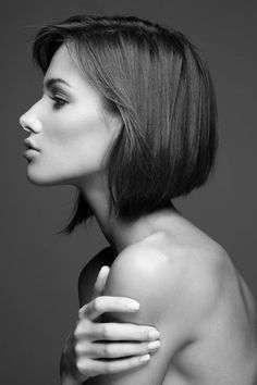 a black and white photo of a woman with shoulder length bob haircut, looking off to the side