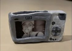 a small television made out of rock with a woman's face on it