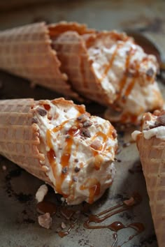 three ice cream cones with caramel drizzle on them