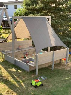 a child's play area in the backyard with sand and water toys on the ground