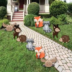 an outdoor lawn decoration with woodland animals on the grass and in front of a house