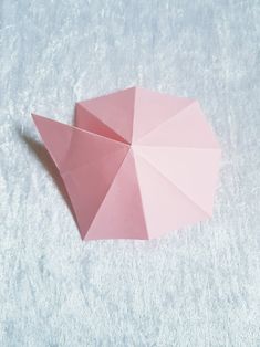 an origami pink umbrella laying on the ground