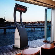 an air purifier sitting on top of a wooden deck next to water