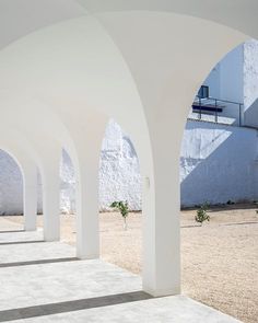 an empty courtyard with arches and white walls