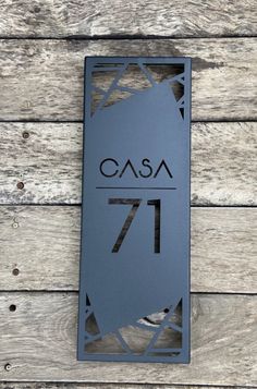 a metal sign that reads casa 17 on the side of a wooden planked wall