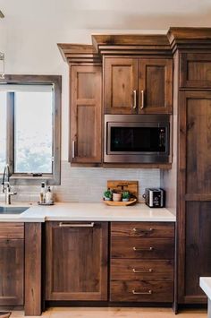 a kitchen with wooden cabinets and white counter tops, along with a window over the sink