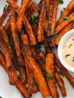 a white plate topped with french fries next to a bowl of ranch dressing on top of it