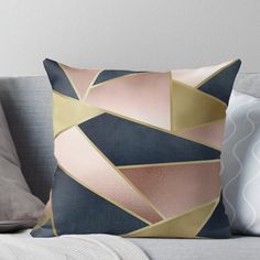 a throw pillow with an abstract design in gold, blue and pink on top of a couch