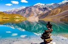 rocks stacked on top of each other in front of a mountain lake