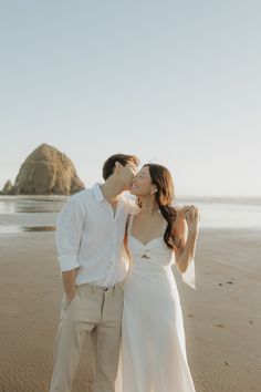 a newly married couple kissing on the beach