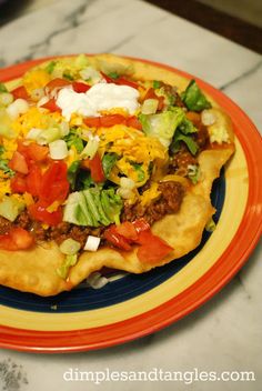 a colorful plate topped with a pizza covered in lots of toppings on top of it