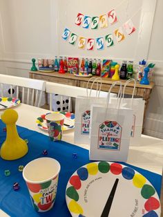 a party table set up with paper plates, cups and napkins for children's birthday