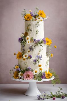 a three tiered cake with flowers on the top and bottom layer, sitting on a white pedestal