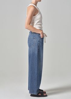 The Brynn Jean is cut in a lightweight denim and designed with a wide leg, a drawstring waist, and a full length inseam. Can easily go from beach to dinner with the addition of some jewelry and a strappy heel. This fit is true to size. Looks Like: Saturated, deep indigo with fading down the thigh and finished hemsFeels Like: Midweight, rigid, organic cotton with relaxed drape for ease From our HUMANITY Collection Jeans Streetwear, Drawstring Trousers, Nye Outfits, Summer Denim, Fashion Jeans, Streetwear Y2k, Knit Skirt, Knit Jacket, Atlantis