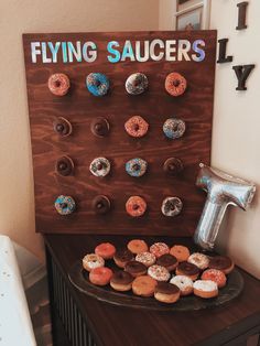 a sign that says flying saucers on it next to some doughnuts and balloons