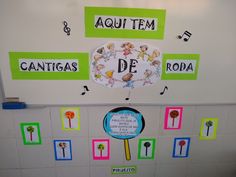 there is a bulletin board on the wall with words and pictures around it that read, aquautem, cantagas de roda