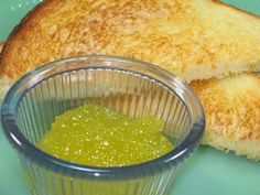 two pieces of toast with green sauce in a bowl next to it on a blue plate