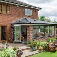 a brick house with an enclosed patio and sitting area