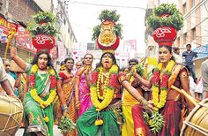 some people are dressed in colorful costumes and holding drums while walking down the street with other people