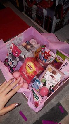 a pink box filled with lots of different types of items on top of carpeted floor