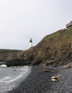 a light house on top of a hill next to the ocean