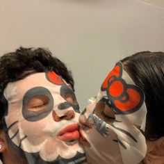 two people with their faces painted to look like cats