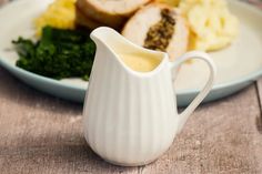 a white pitcher sitting on top of a plate filled with food