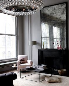 a living room filled with furniture and a large mirror on the wall over a fire place