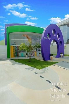 a building with a large purple and green object in front of it's entrance