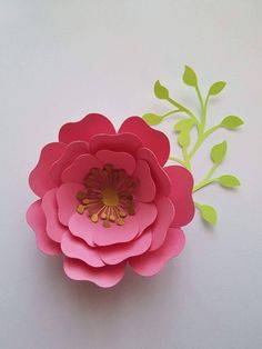 pink paper flowers with green leaves on white background