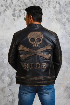 Skull and Crossbones Biker Leather Jacket Skull motorcycle jacket is manufactured from finest genuine cowhide leather. It features embossed skull and crossbones with “RIDE”, emanating the adventurous biker aura. This hand distressed leather jacket includes snap-button collar, front zipped closure with spacious pockets on its cool black exterior along with quilted padded sleeves & shoulders. This skull leather jacket is a perfect outerwear for embracing your biker spirit, with the premium quality Distressed Moto Leather Jacket For Biker Events, Distressed Leather Biker Jacket For Biker Events, Rugged Distressed Brown Leather Jacket For Biker Events, Moto Biker Jacket In Distressed Brown For Biker Events, Gothic Leather Biker Jacket For Biker Events, Gothic Leather Biker Jacket For Events, Distressed Brown Moto Leather Jacket For Biker Events, Distressed Biker Leather Jacket For Biker Events, Rugged Distressed Leather Jacket For Biker Events