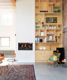 a living room filled with furniture and a fire place next to a wall mounted fireplace