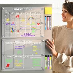 a woman standing in front of a magnetic dry eraser board with markers on it