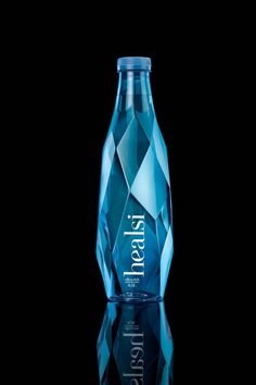 a blue glass bottle sitting on top of a black table next to a dark background