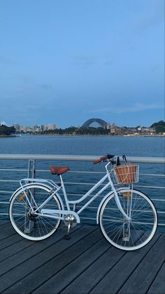 a white bicycle parked on top of a wooden pier